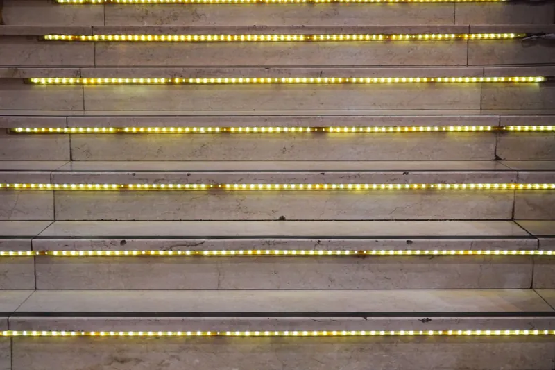 Warm LED strip lights glowing along each step of a modern staircase