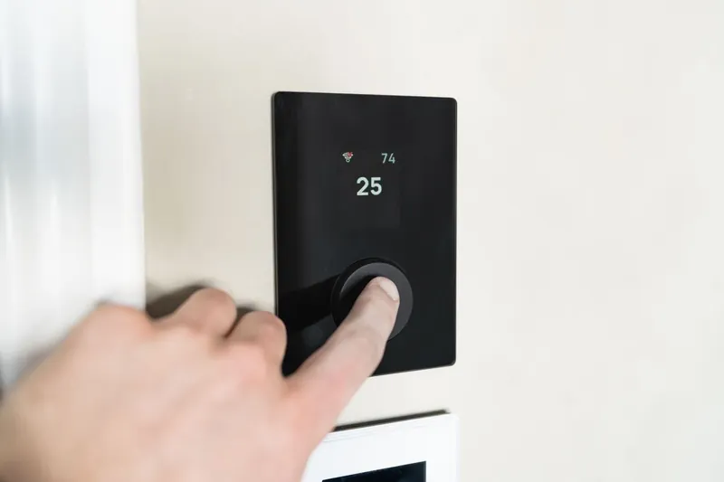 Smart thermostat mounted on a living-room wall