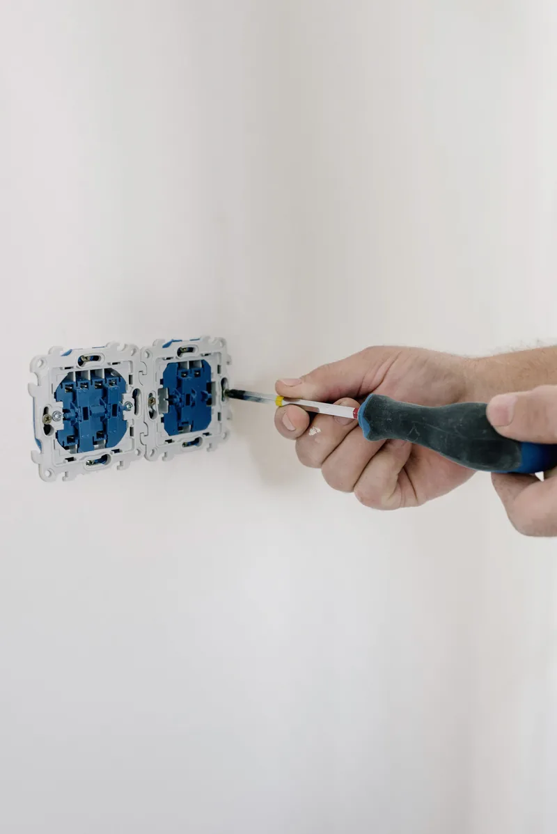 Close-up of a white GFCI electrical outlet with TEST and RESET buttons on a wall