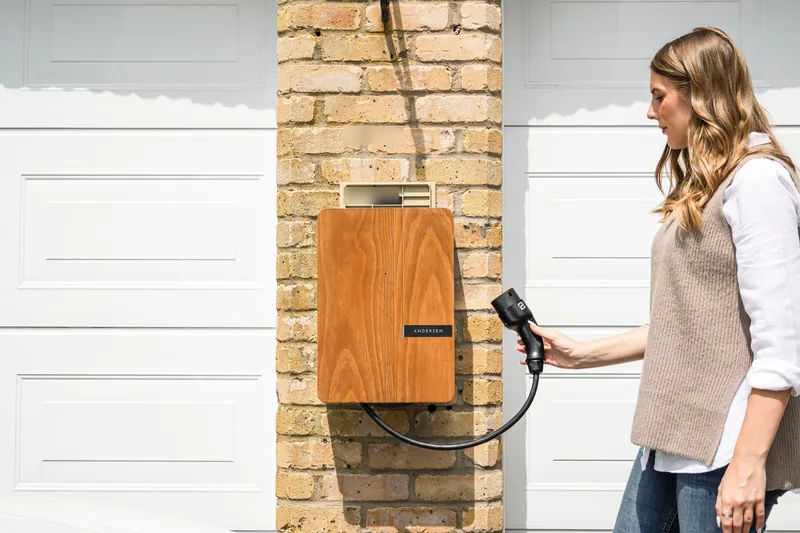 Electrician mounting a home EV charging station on a garage wall